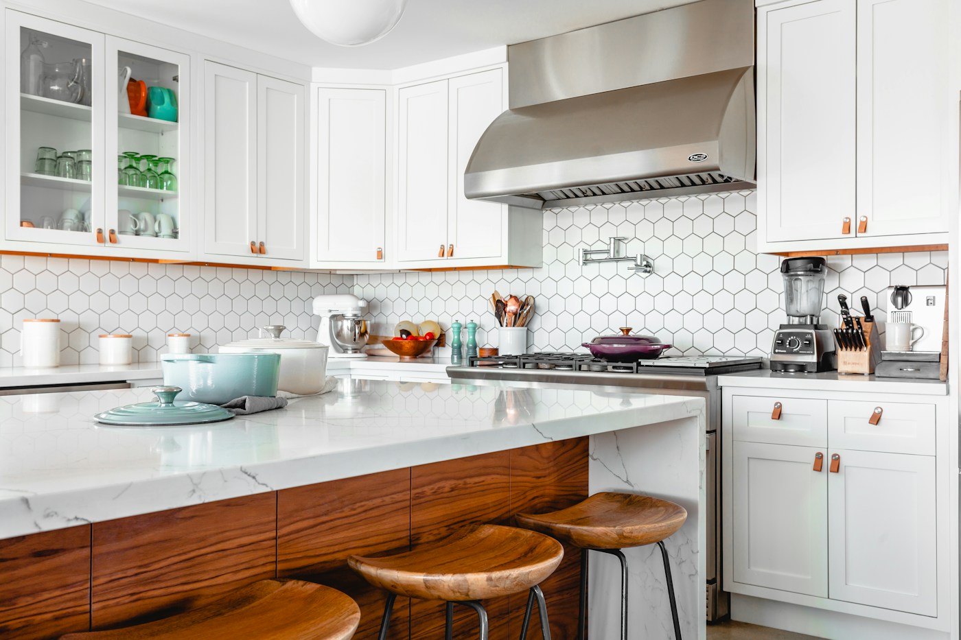 A sunlit kitchen with warm wood, clear counters, and leafy plants